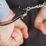 hands-with-handcuffs-clenching-fists_13339-4835